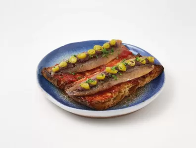 Tosta de sardina ahumada con mermelada de tomate, olivada y piparra